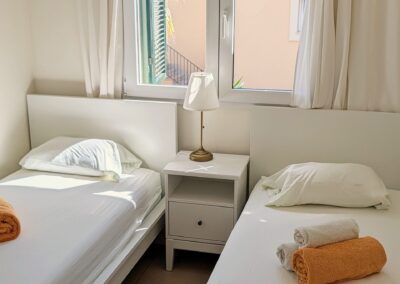 Schlafzimmer mit zwei Einzelbetten und bereitgelegten Handtüchern