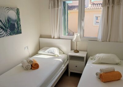 Zweites Schlafzimmer mit zwei Einzelbetten und dekorativem Wandbild