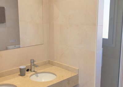 Badezimmer mit Doppelwaschbecken und Duschkabine