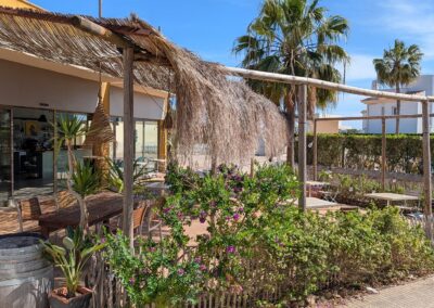 Strandbar der Anlage mit Palmwedel-Pergola und mediterraner Bepflanzung